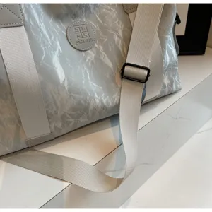 Detailed view of grey travel duffel gym bag with sturdy straps and branded logo patch.