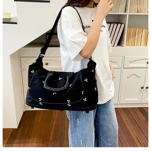 Black canvas travel duffel bag with cute bow embroidery, large capacity gym shoulder bag.