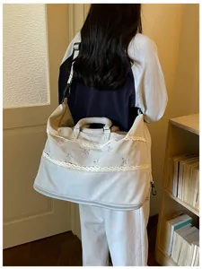 Detail view of large capacity travel gym bag, featuring lace trim and cute bow embroidery.