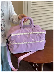Close-up detail of the light purple travel duffel bag featuring elegant lace trim and bows.