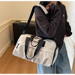 Vue détaillée du grand sac de voyage de fitness à motif quadrillé gris clair avec brides noires.