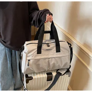 Grand sac de voyage de sport avec motif à carreaux, poignées robustes et sangle.