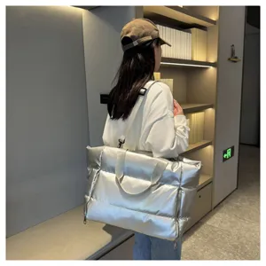 Silver padded puffer shoulder gym bag detail view, spacious travel tote for women daily use.