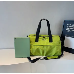 Detail du sac de voyage carre vert, montrant des poignees solides et une conception pratique.