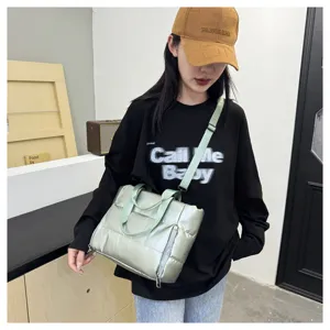 Detailed view of the stylish green puffer shoulder bag, featuring a convenient zipper pocket.