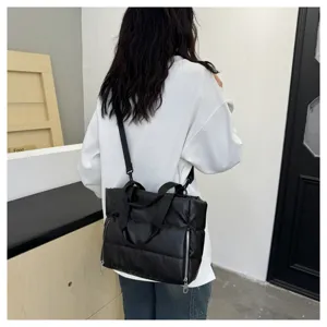 Black quilted shoulder bag, casual puffer tote with zipper pockets and top handles.