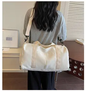 Detailansicht der weißen Reisetasche mit Sternenmuster bequem über der Schulter getragen.