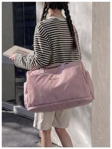 Pink large capacity travel duffel bag detail showing durable shoulder strap and front pocket.