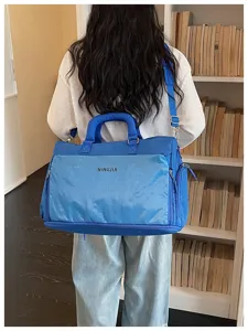 Detailed view of the blue large capacity travel duffel bag showing front grid pocket and straps.
