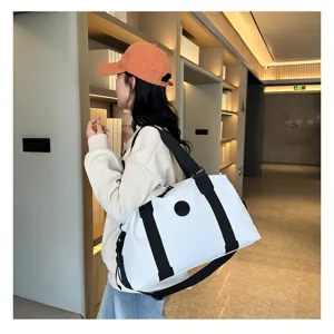Detail shot of white travel gym bag with black straps in modern interior scene setting.