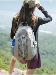 Outdoor hiking backpack detail view, featuring durable grey fabric, mesh side pocket, and cords.