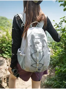 Detail shot of outdoor backpack in light grey, showing back view and elastic cord design for hiking.