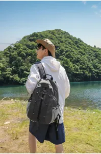 Outdoor travel backpack detail view, featuring durable grey fabric and elastic cord setup.