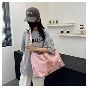 Pink quilted travel duffel bag detail, large capacity gym bag scene showing carrying way.