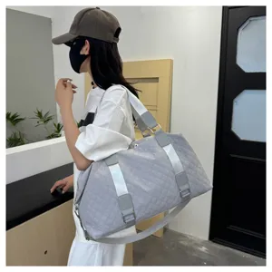 Grey quilted travel duffel bag shown in casual lifestyle setting, perfect for short trips.