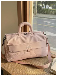 Pink quilted travel duffel bag for women, lightweight waterproof gym bag with large capacity.