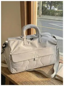 Quilted travel duffel bag detail, large capacity gym storage bag with soft handle and strap.