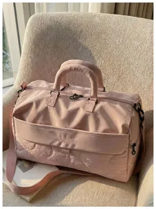Detailed view of the pink travel duffel bag showing textured fabric and front pocket design.