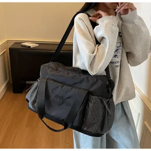 Durable black travel and fitness duffel bag with side plaid pockets and spacious main compartment.