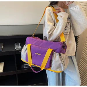 Detail scene showing the stylish purple and yellow travel bag worn by model in use.