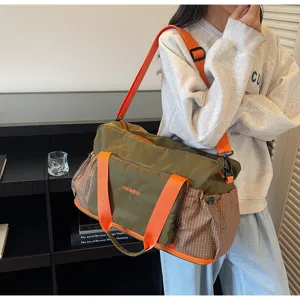 Detail view of travel duffel gym bag with orange straps, wet dry compartments, and front pocket.