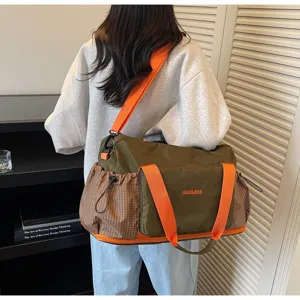 Detailed view of the large capacity travel duffel bag with orange straps and pockets.