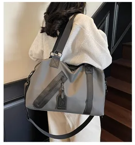 Vue détaillée du grand sac de voyage avec séparation humide et sèche et bandoulière.