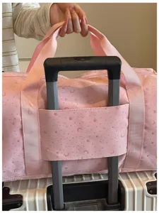 Detailansicht des sehr praktischen Koffer-Gepäckriemens der rosa Stern-Reisetasche.