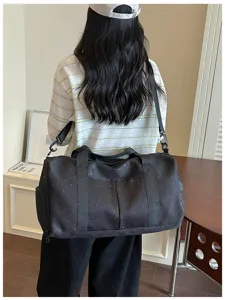 Detailansicht der schwarzen Reisetasche mit Sternen und Monden vom Model getragen.