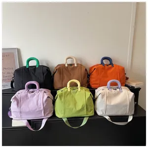 Large capacity canvas travel duffel bag with contrast handles and shoulder strap.