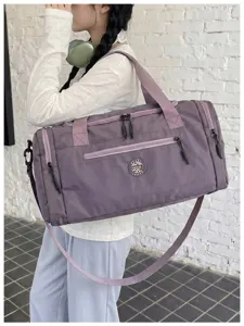 Side carry detail of purple travel duffel bag with shoulder strap and durable fabric.