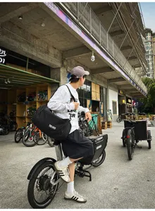 Outdoor lifestyle detail shot of a black travel duffel bag on a bicycle, durable and spacious.
