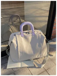 Large capacity canvas travel duffel bag detail, stylish purple handles and adjustable strap.