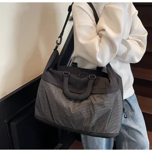 Detail shot of the expandable travel duffel bag showing grid texture and sturdy handles.