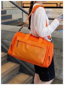 Outdoor scene detail of the orange waterproof travel duffel bag with wet dry separation.