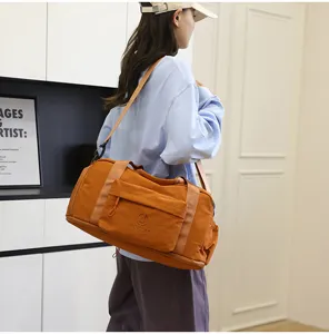 Stylish large capacity waterproof travel duffel bag in orange, ideal for gym and outdoor trips.
