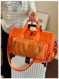 Orange waterproof travel duffel bag gym bag with wet dry separation and front pocket detail.