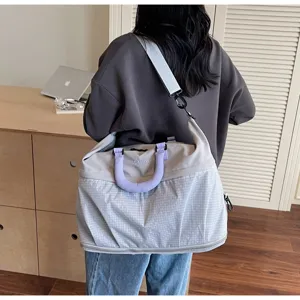Detailed view of the large capacity grey grid travel fitness duffel bag with shoulder strap.