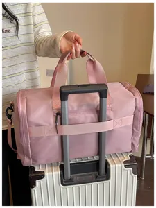 Pink travel duffel bag detail showing trolley sleeve and reinforced handles for gym use.