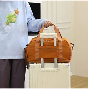 Detail view of brown travel duffel bag featuring luggage sleeve and durable canvas for trips.