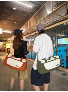 Detailed view of stylish duffel bag with contrasting colors and shoulder strap for travel.