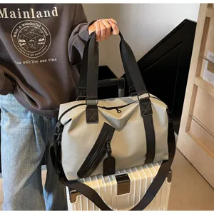 Grand sac de voyage avec séparation humide-sec, anses robustes et design élégant et pratique.