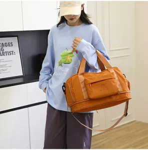 Detail view of large capacity waterproof travel duffel bag in orange, ideal for gym and trips.