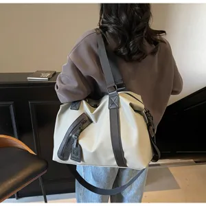 Vue détaillée du grand sac de voyage avec fermeture éclair diagonale et sangles robustes.