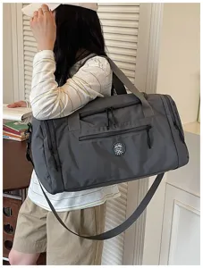 Dark grey travel duffel bag with shoulder strap and multiple zipper pockets for storage.