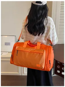 Detail shot of orange large-capacity waterproof travel duffel bag with wet-dry separation.