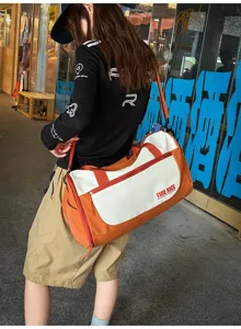 Detail view of the large capacity travel duffel bag with stylish orange and white design.