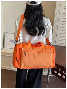 Detailed view of the orange travel duffel bag with dry-wet separation and large capacity.