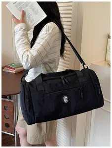 Black waterproof travel duffel bag detail showing shoulder strap and durable fabric for use.