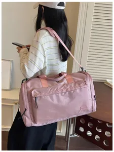 Detail view of the pink waterproof gym duffel bag showing strap and side pocket design.